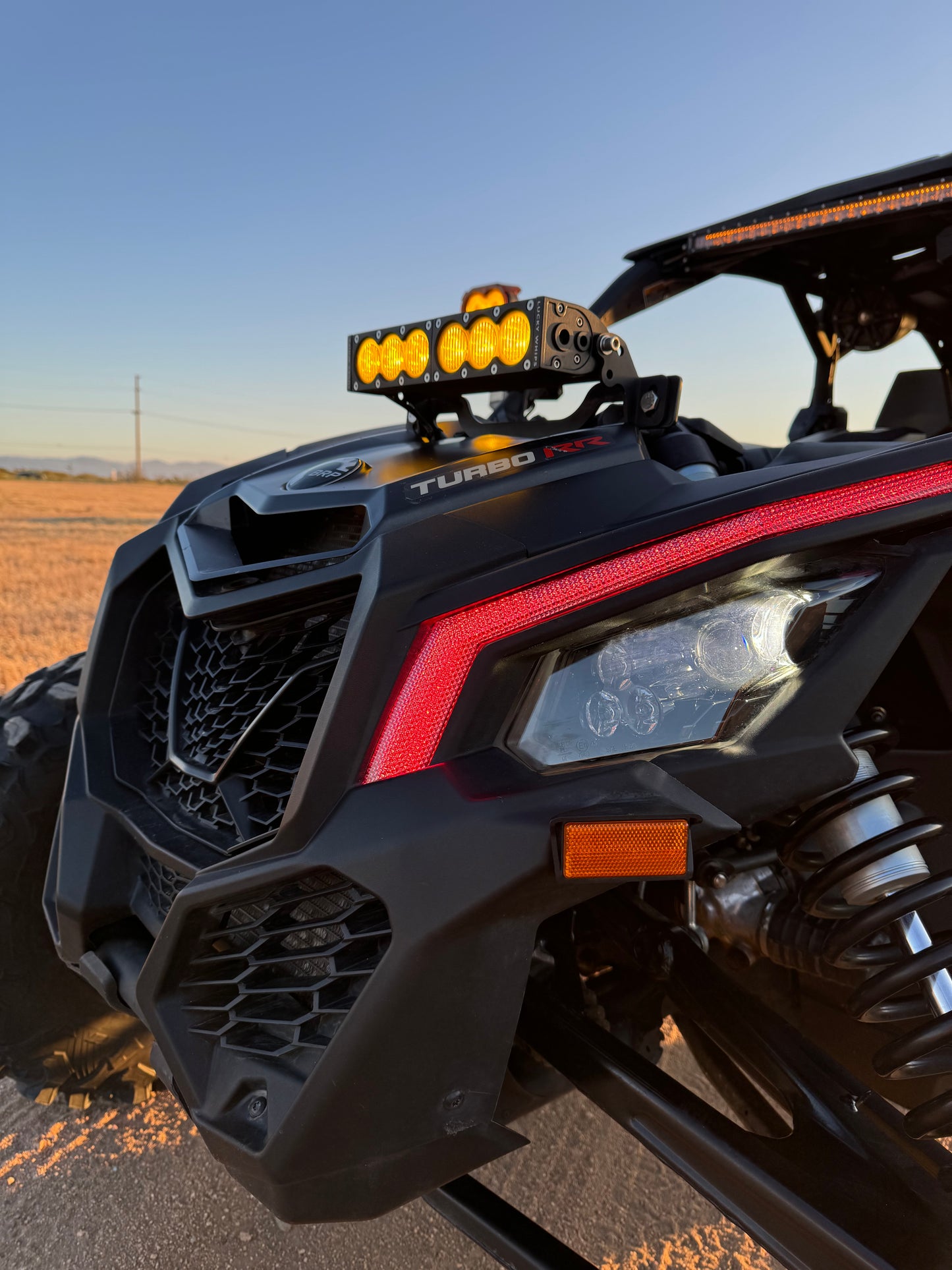 Can Am X3 RGBW Brow Lights installed on the front of a Can Am X3 side-by-side vehicle, providing vibrant lighting.