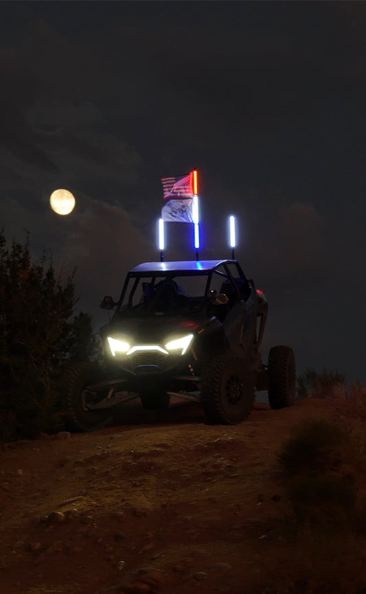 Colorful LED whips by Lucky Whips, illuminated and waving in the night sky, showcasing vibrant light patterns.