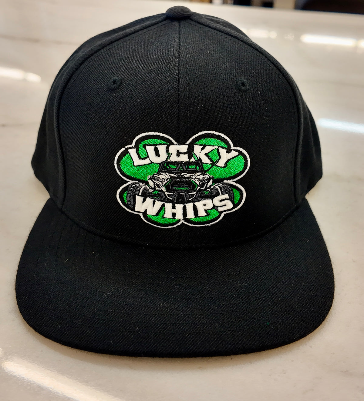 Lucky Whips classic flat bill hat featuring a sleek design and adjustable strap, perfect for casual wear.