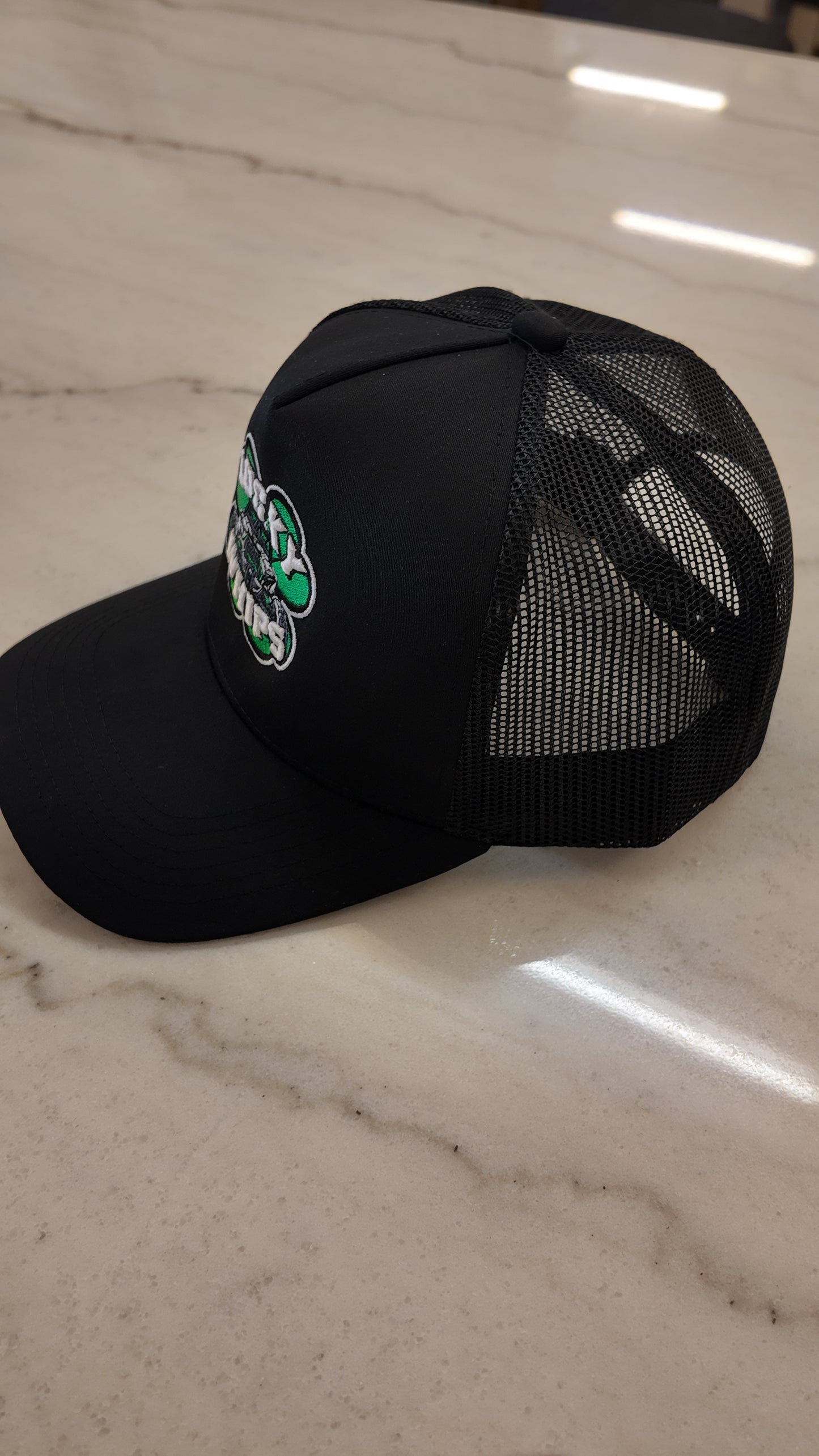 Lucky Whips Trucker Curve Bill Hat featuring a classic mesh back and adjustable snap closure in a stylish design.