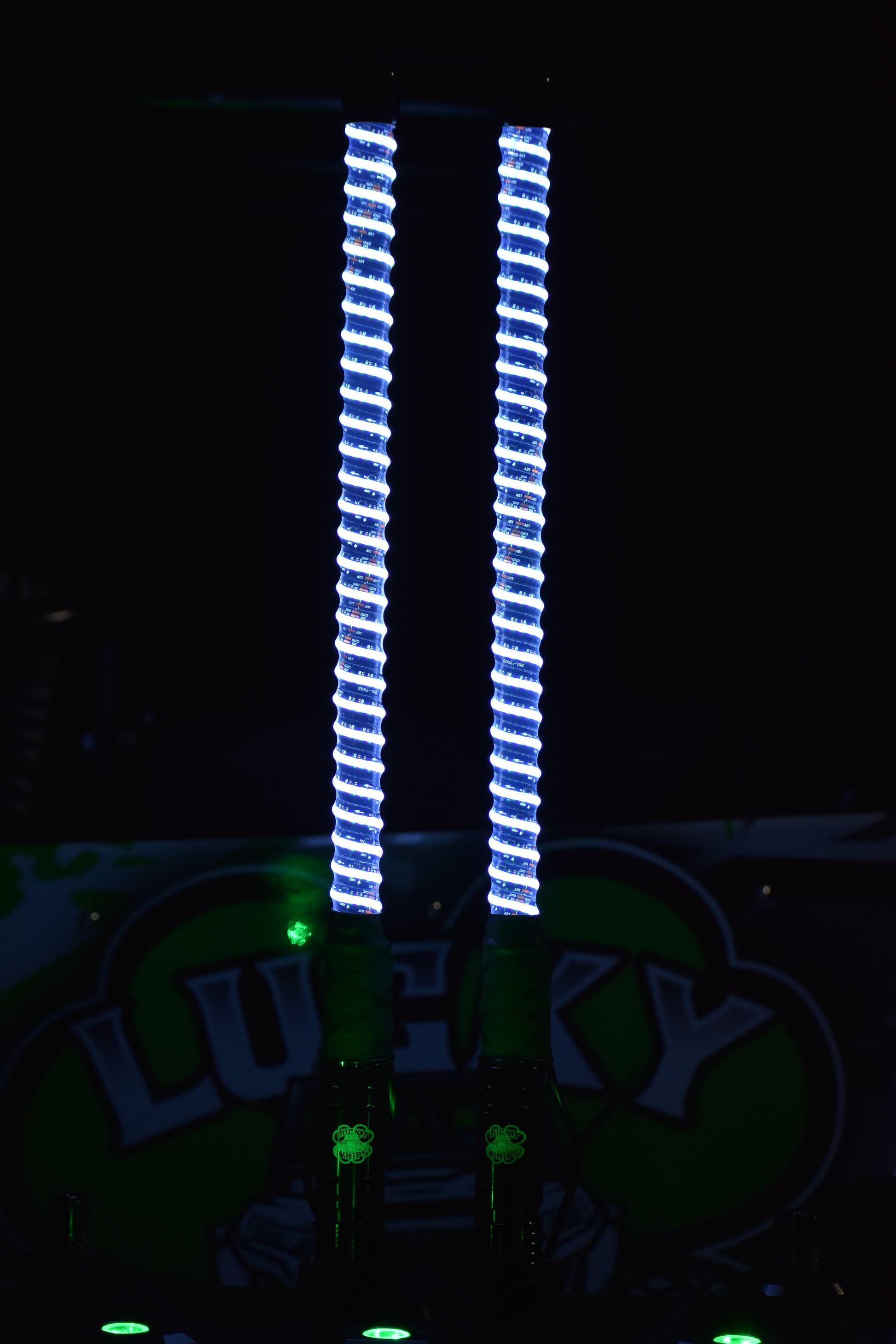 Colorful G1 LED Whips by Lucky Whips illuminated against a dark background, showcasing vibrant light patterns.