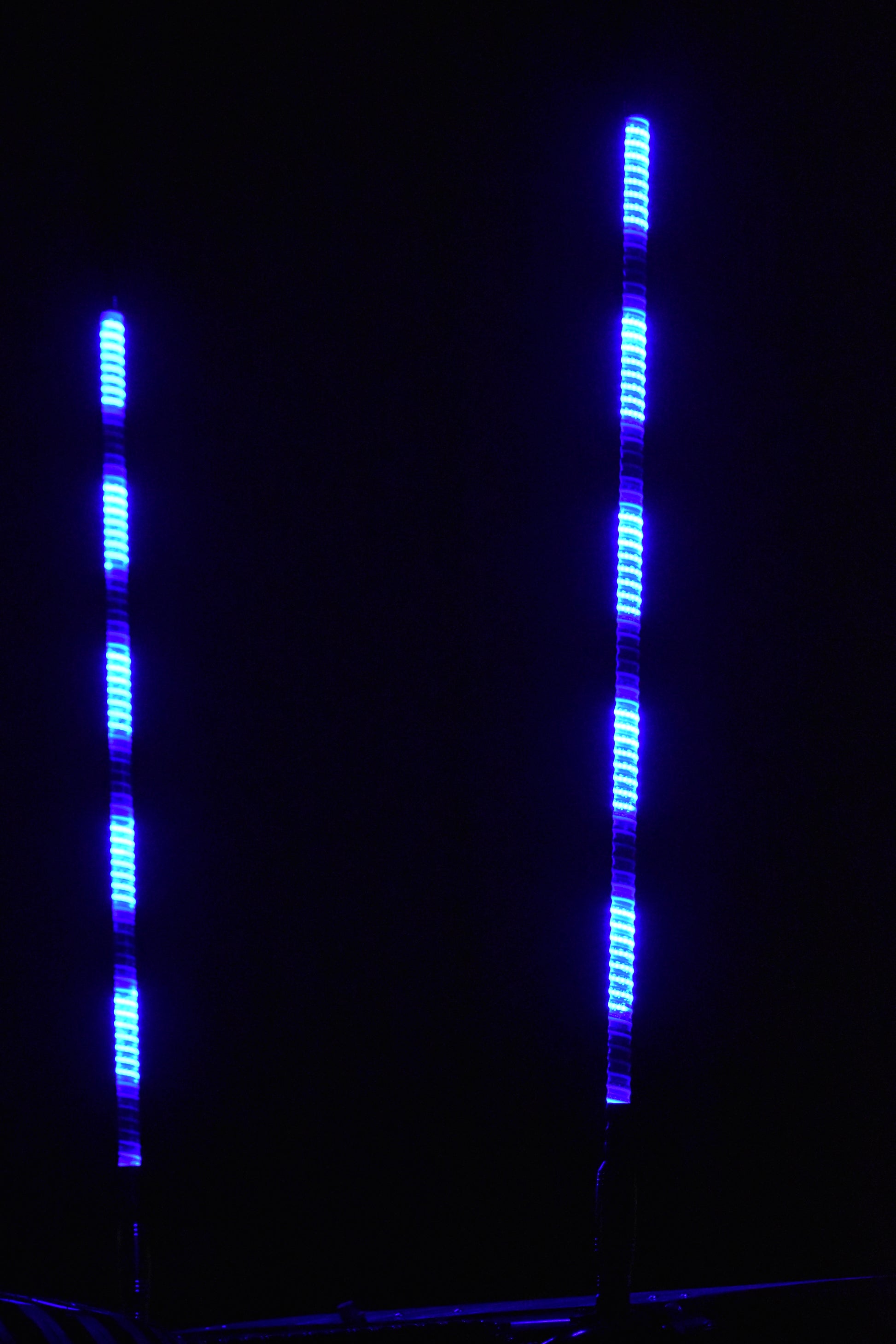 Colorful G1 LED Whips by Lucky Whips, illuminated with vibrant lights against a dark background.