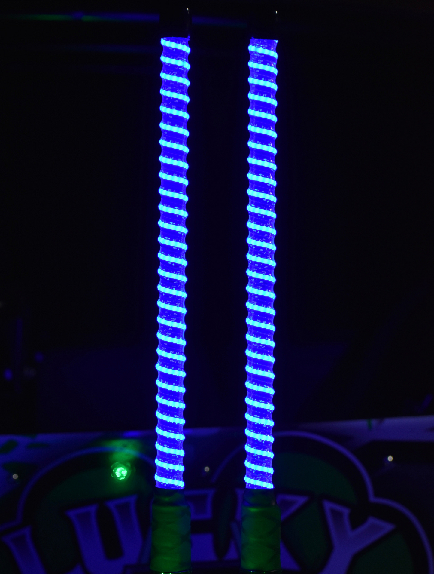 Colorful G1 LED Whips by Lucky Whips, glowing brightly against a dark background, showcasing their vibrant LED lights.