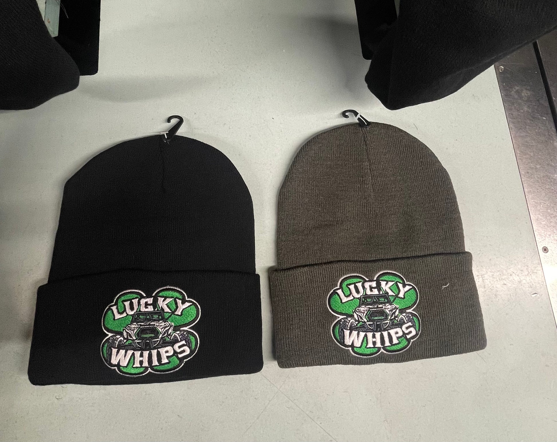 Lucky Whips gray beanie displayed on a wooden surface, featuring a snug fit and soft knit texture.