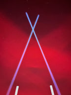 Pair of Lucky Whips Laser Pod Lights displaying colorful laser patterns against a dark background.