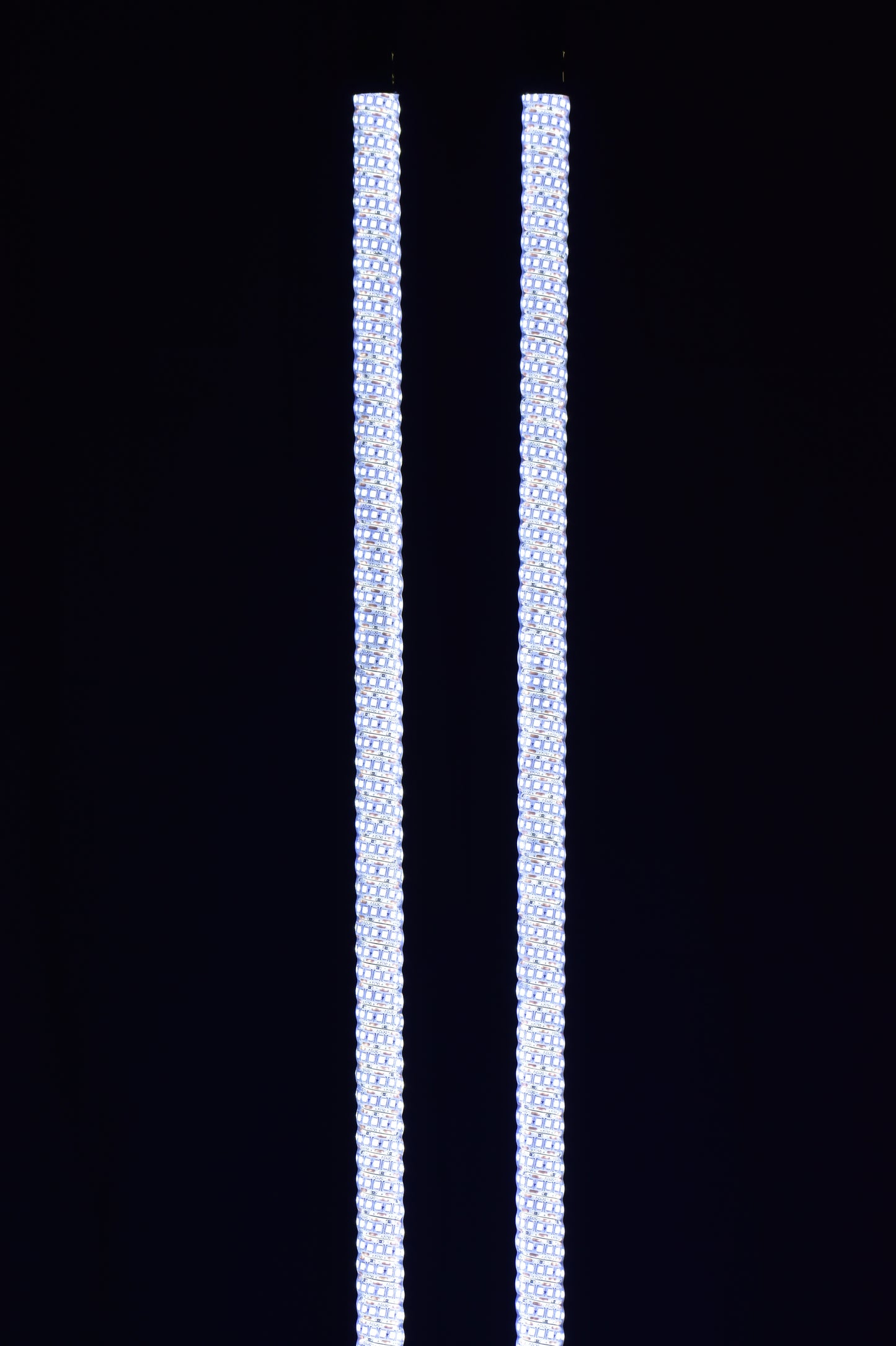 Colorful LED whips by Lucky Whips glowing in the dark, showcasing dynamic light patterns against a nighttime backdrop.