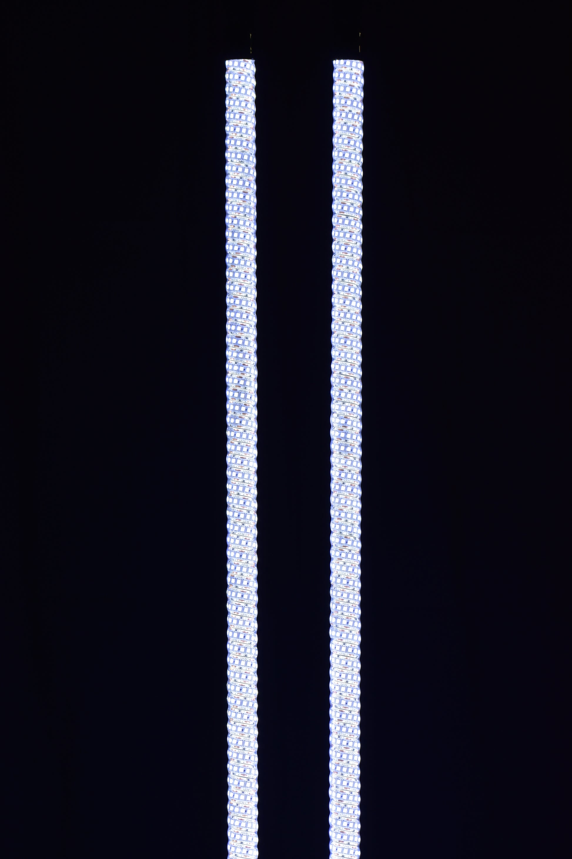 Colorful LED whips by Lucky Whips glowing in the dark, showcasing dynamic light patterns against a nighttime backdrop.