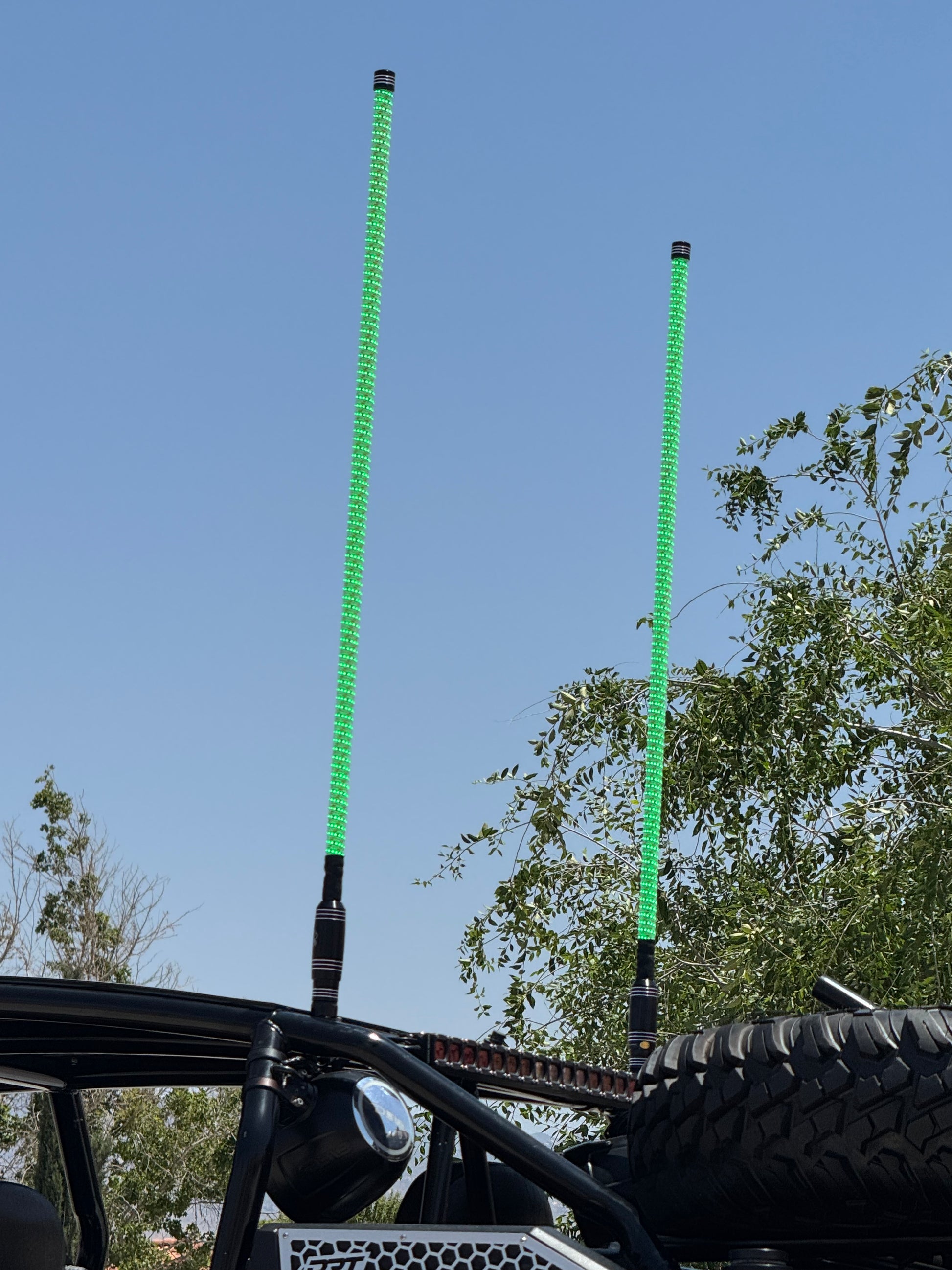 Lucky Whips LED whips glowing in vibrant colors against a dark background, showcasing their flexible design and brightness.