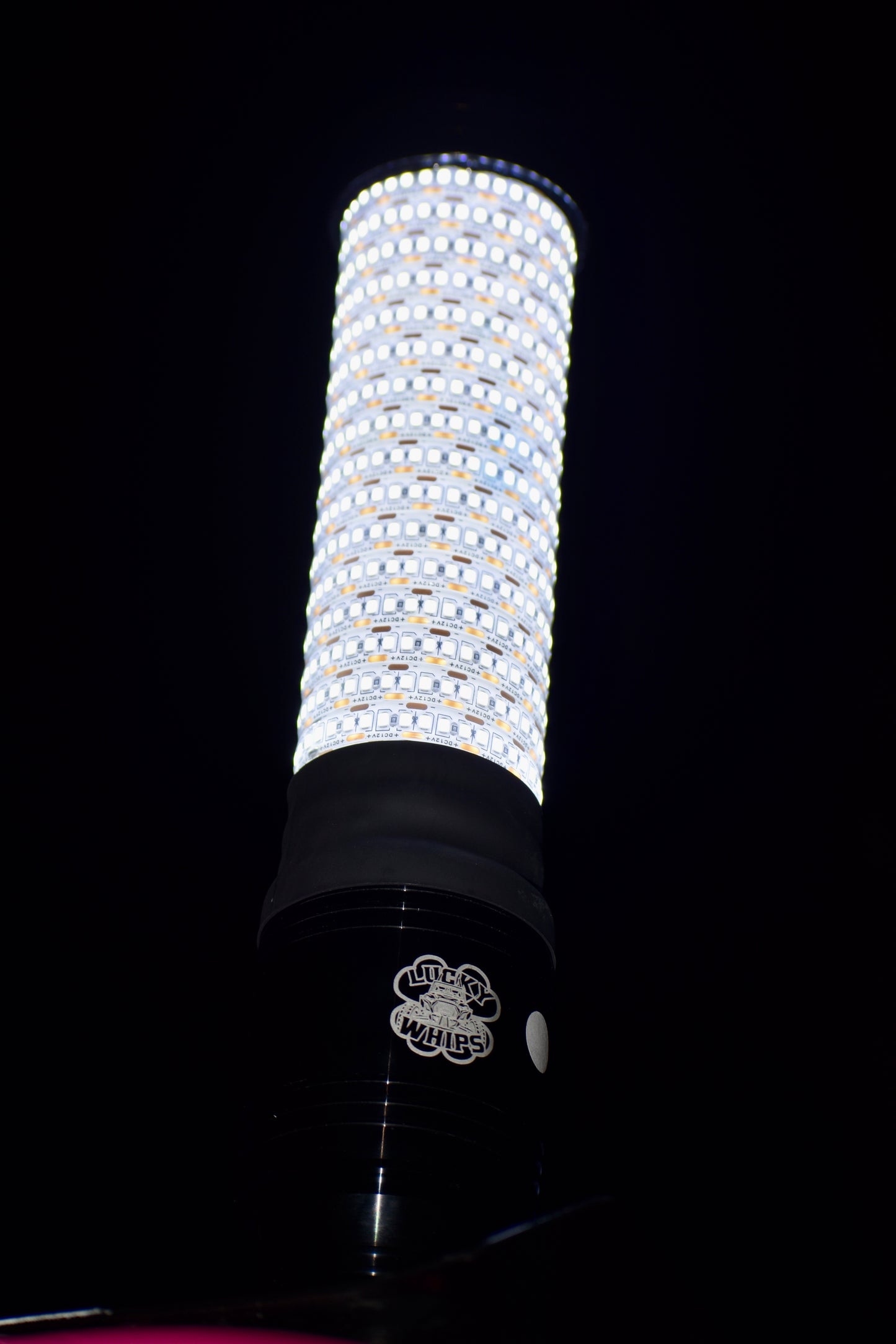 LED whips by Lucky Whips illuminated in vibrant colors against a dark background, showcasing their flexible design.