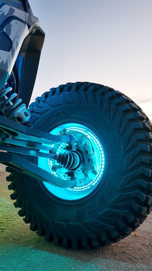 Lucky Whips RGB wheel ring lights illuminating a car's wheels with vibrant colors in a nighttime setting.