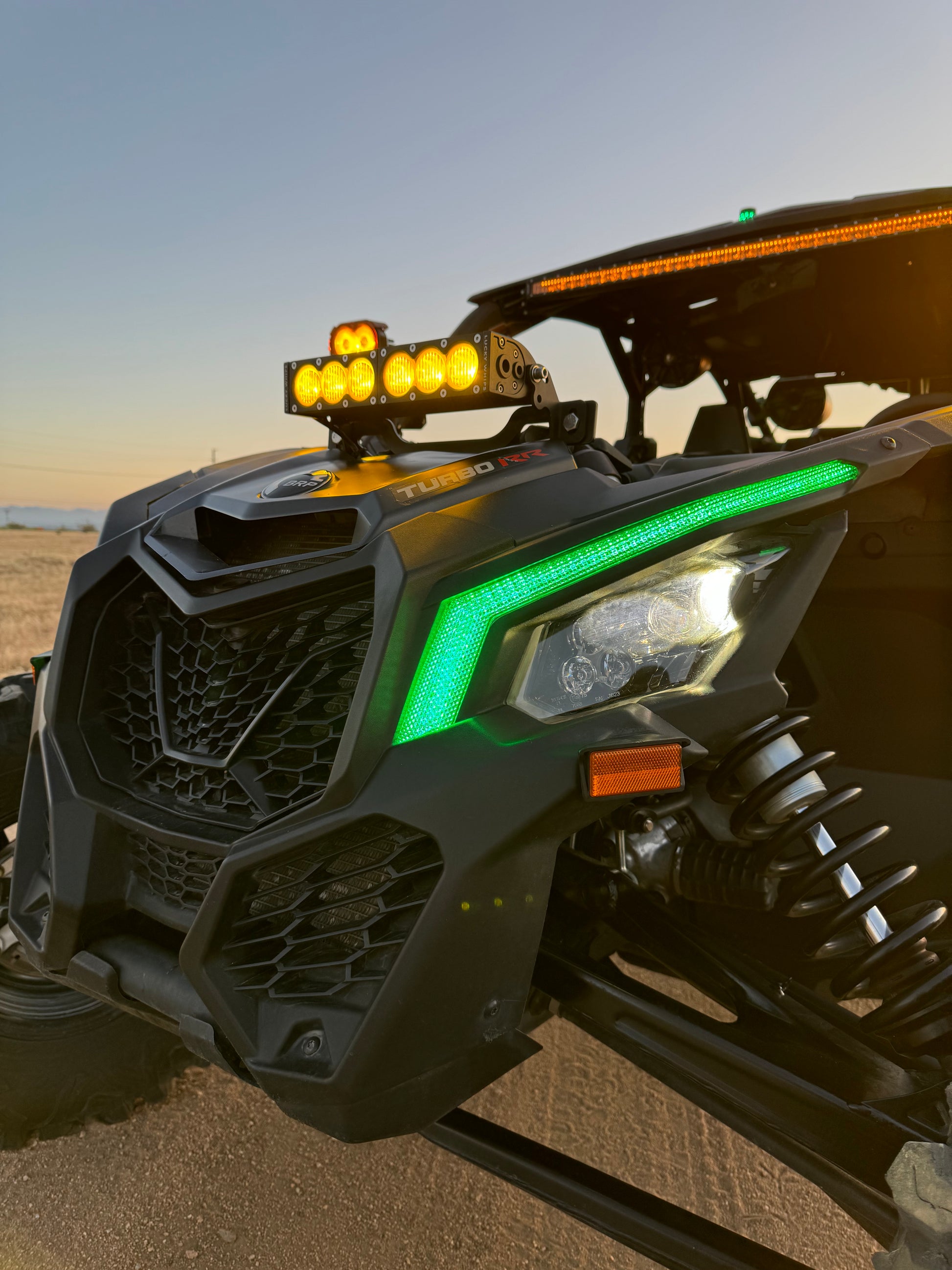 Can Am X3 RGBW Brow Lights installed on side of Can Am X3 off-road vehicle, featuring vibrant multicolor LED lighting.